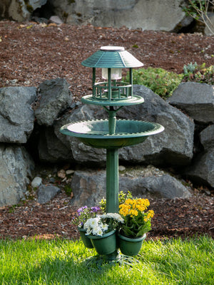 Three-in-one Solar Light Bird Bath and Planter Garden Centerpiece outdoors with yellow and white flowers